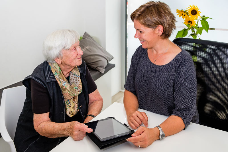 Logopädin und Patientin arbeiten gemeinsam am Tablet