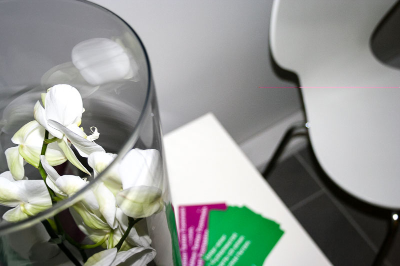 Detailaufnahme: Orchideen und Visitenkarten der Praxis